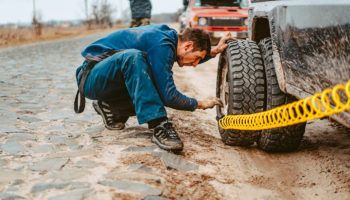man pumps air wheel with compressor