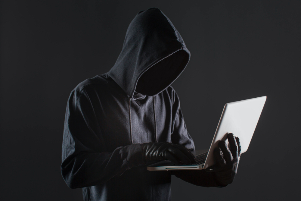 side view male hacker with gloves laptop