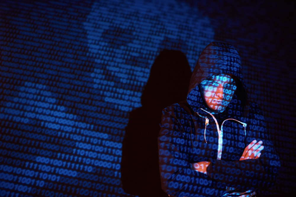 cyber attack with unrecognizable hooded hacker using virtual reality digital glitch effect